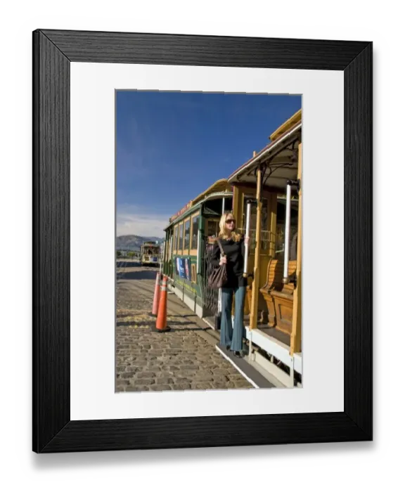 Framed Print : San Francisco pretty blond female in sunglasses holding on to cable car at Friedel