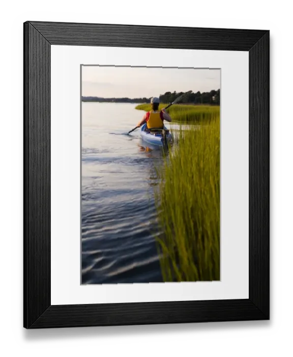 Framed Print : A woman kayaks in a marshy section of the Connecticut River in Old Lyme, Connecticut Framed Print : A woman kayaks in a marshy section of the Connecticut River in Old Lyme, Connecticut