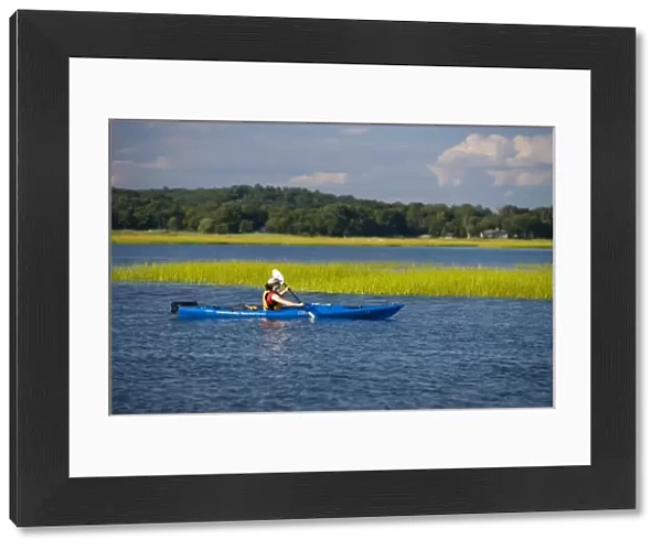 A woman kayaks near the mouth of the Connecticut River in Old Lyme, Connecticut