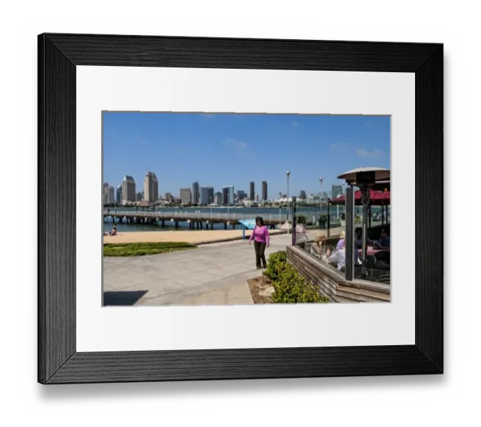 Framed Print : Woman walking on pavement with scenic of skyline of San Diego from Coronado Island