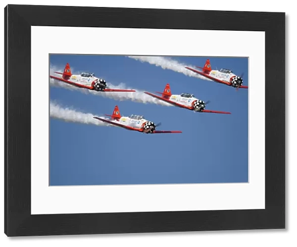 Aero Shell Aerobatic Team in T-6 Texans and is trailing smoke in the sky