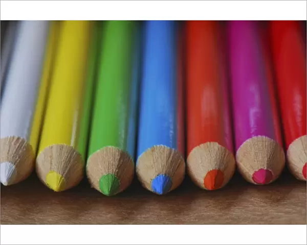 USA, Row of multicolored colored pencils lay on table