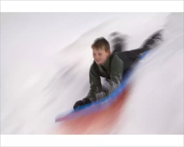 United States, Washington, Crystal Mountain, boy on sled in motion (MR)