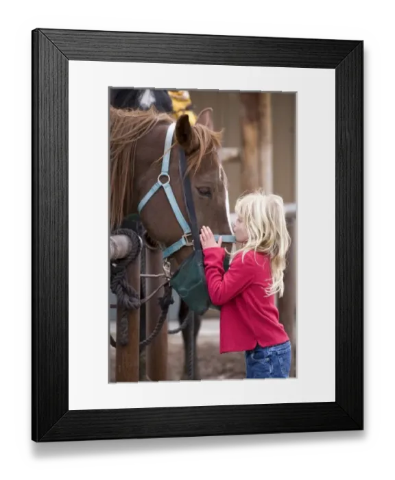 Framed Print : USA. Wyoming. Grand Tetons National Park. Young girl gives a kiss to a horse in a Tetons stable