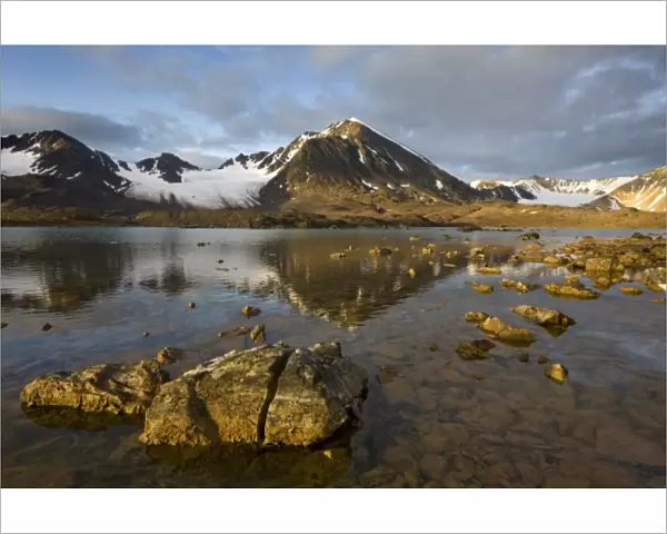 Norway, Svalbard, Spitsbergen, Rising midnight sun lights glacier-covered mountains
