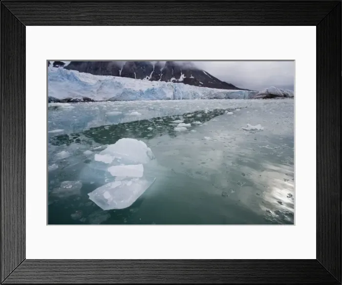 Framed Print : Small ice pieces drifting in fiord near glacier, June, dark and cloudy sky Framed Print : Small ice pieces drifting in fiord near glacier, June, dark and cloudy sky