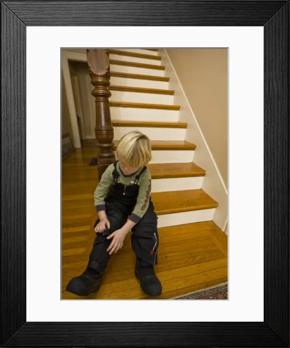 Framed Print : A young boy (age 5) prepares to go outside in the winter in Portsmouth, New Hampshire Framed Print : A young boy (age 5) prepares to go outside in the winter in Portsmouth, New Hampshire