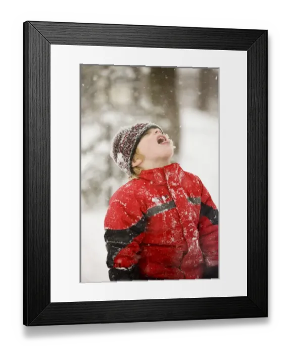 Framed Print : A young boy catches snowflakes with his mouth during a snowstorm in Portsmouth, New Hampshire