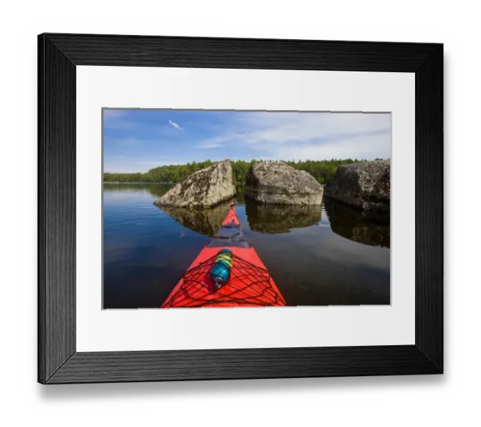 Framed Print : The bow of a kayak points at two large boulders in Branch Lake in Ellsworth, Maine