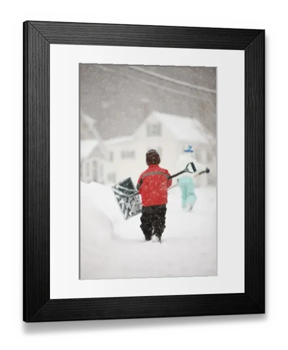 Framed Print : A brother and sister shovel snow during a snowstorm in Portsmouth, New Hampshire Framed Print : A brother and sister shovel snow during a snowstorm in Portsmouth, New Hampshire