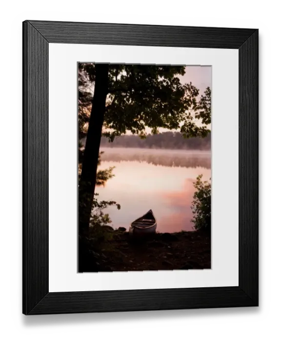 Framed Print : A canoe rests on the shore of Pawtuckaway Lake at dawn as seen from Horse Island