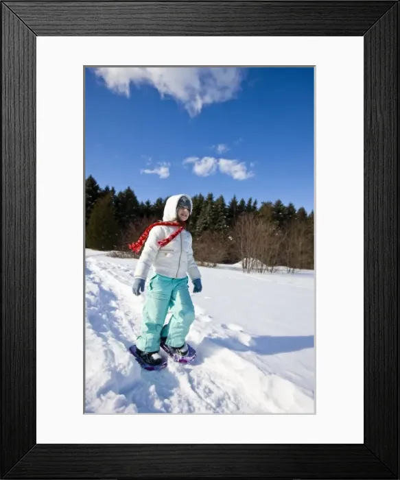 Framed Print : A girl (age 7) snowshoes through a snowy field at the Urban Forestry Center in Portsmouth