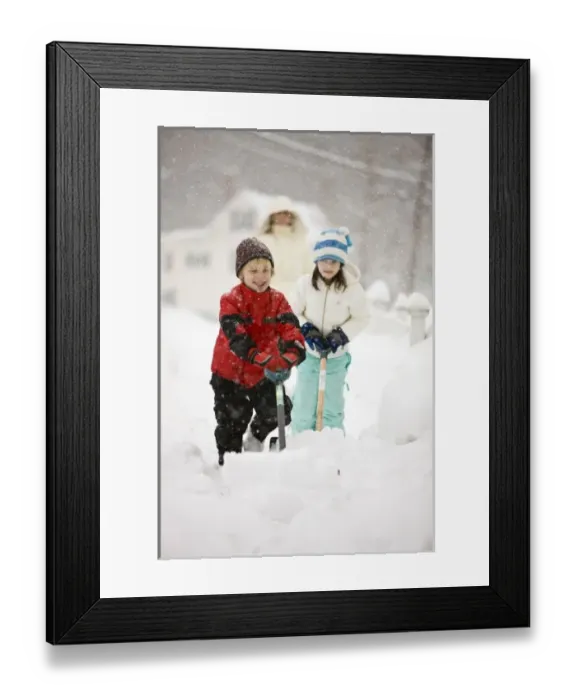 Framed Print : A brother and sister shovel snow during a snowstorm in Portsmouth, New Hampshire Framed Print : A brother and sister shovel snow during a snowstorm in Portsmouth, New Hampshire