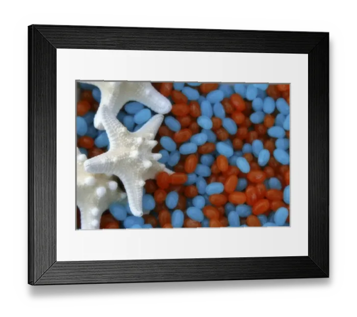 Framed Print : Red and blue jelly beans and white starfish
