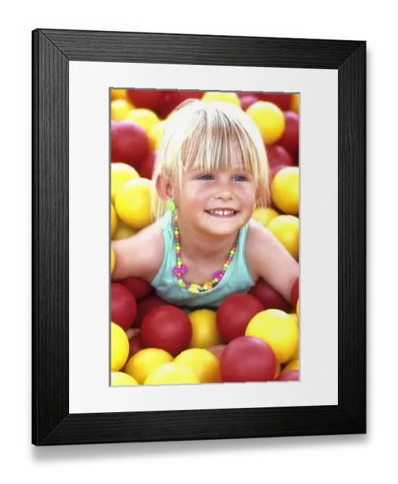 Framed Print : Portrait of a young girl, smiling, having fun on the McDonalds balls playground