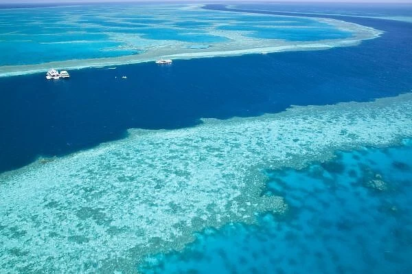 Aerial view of The Great Barrier Reef by the Whitsunday Coast with diving boats anchored
