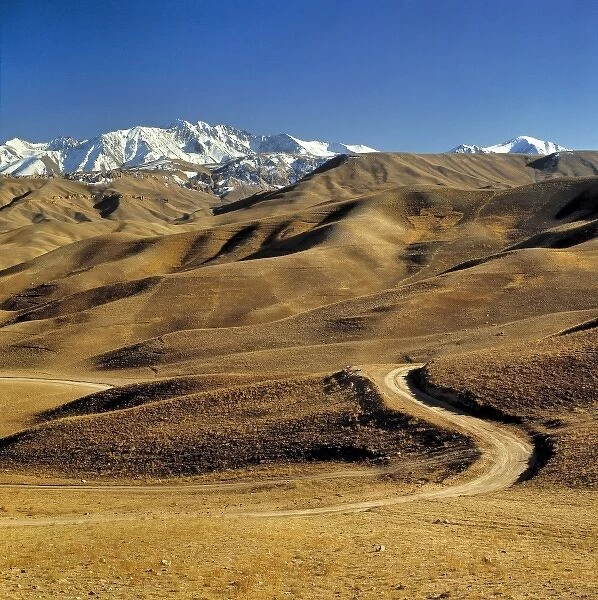 Afghanistan, Hindu Kush Mountains. A lonely dirt road leads into the barren foothills