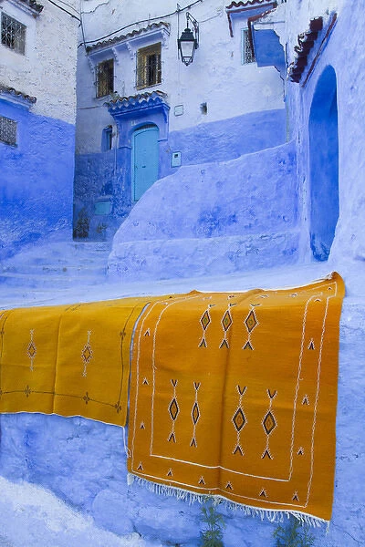 Africa, Morocco, Chefchaouen. Rugs draped on a wall in the blue town