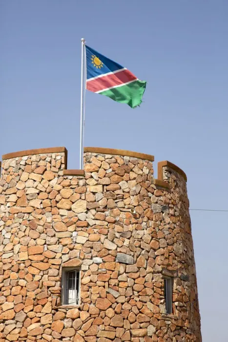 Framed Print : Africa, Namibia, Etosha National Park. Namibian flag flies over brick tower at park entrance