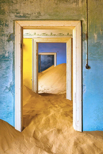 Africa, Namibia, Kolmanskop. Doorways and drifting sand in an abandoned diamond mining town
