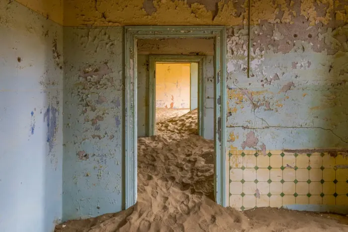 Framed Print : Africa, Namibia, Kolmanskop. Doorways and drifting sand in an abandoned diamond mining town