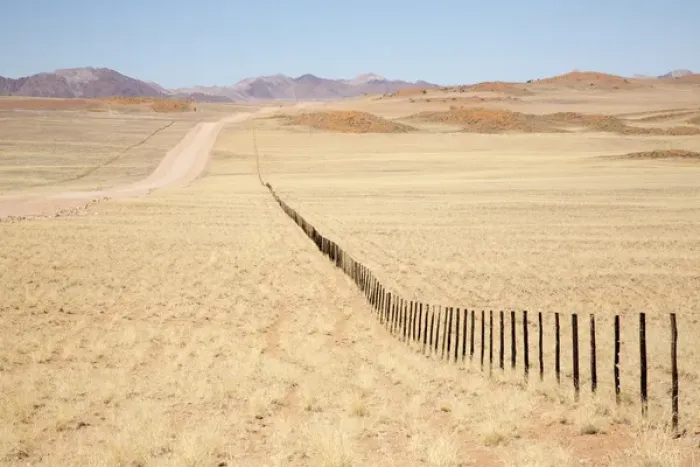 Framed Print : Africa, Namibia, Namib Desert. Long road and fence in desert Framed Print : Africa, Namibia, Namib Desert. Long road and fence in desert