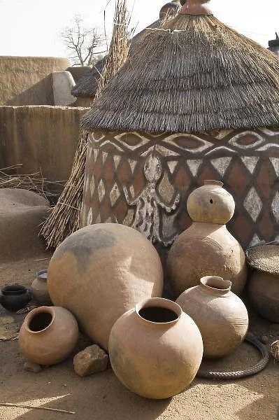 Africa, West Africa, Ghana, Sirigu. Handcrafted pottery leaning against traditional