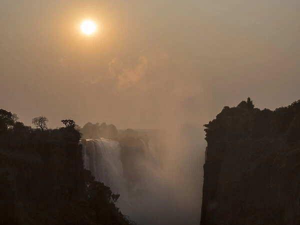 Africa, Zimbabwe, Victoria Falls. View of waterfall at sunrise