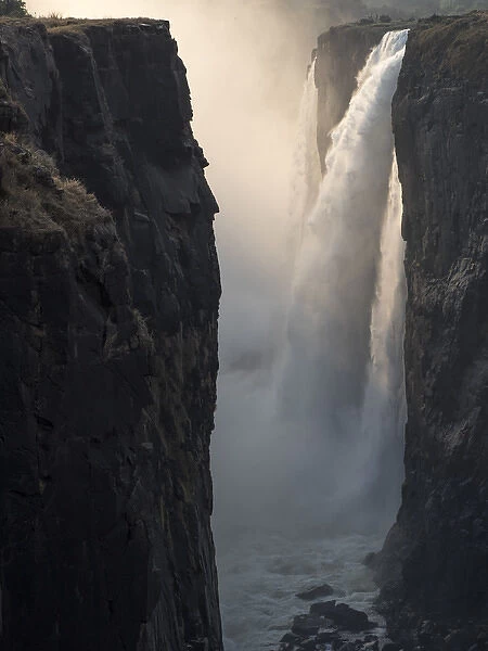 Africa, Zimbabwe, Victoria Falls. Close-up of waterfall and spray at sunrise. Credit as