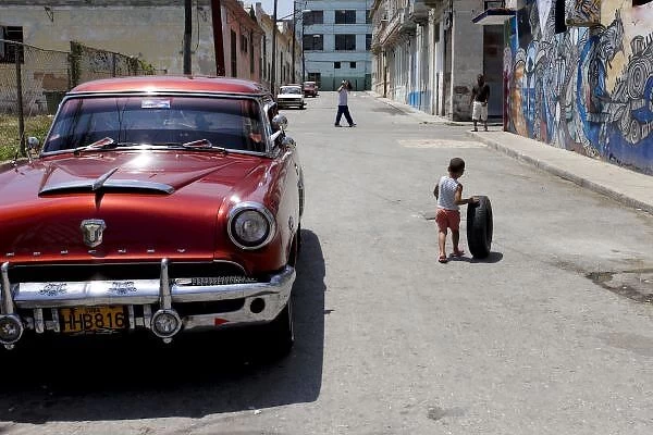 African Hamel district, Havana, Cuba, UNESCO World Heritage City. Child playing with old tire