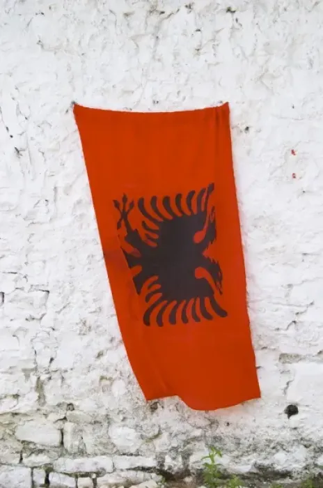 Framed Print : The Albanian flag, red with black double headed eagle, against a white washed stone wall Framed Print : The Albanian flag, red with black double headed eagle, against a white washed stone wall