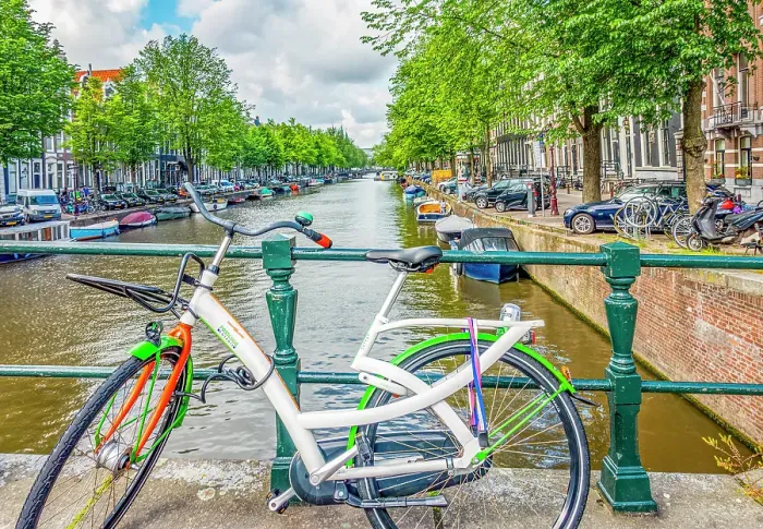 Framed Print : Amsterdam, Netherlands. Wide angle view of brightly painted bicycle locked to a bridge crossing the canal Framed Print : Amsterdam, Netherlands. Wide angle view of brightly painted bicycle locked to a bridge crossing the canal