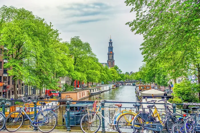 Framed Print : Amsterdam, Netherlands. Wide angle view of Munttoren Tower at end of canal lined with boats and trees Framed Print : Amsterdam, Netherlands. Wide angle view of Munttoren Tower at end of canal lined with boats and trees