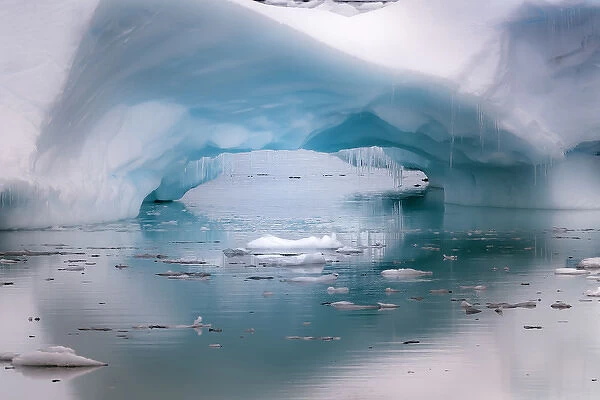 Antarctica. Artistic open arch in an iceberg