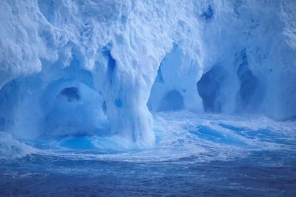 Antarctica. Iceberg with breaking waves