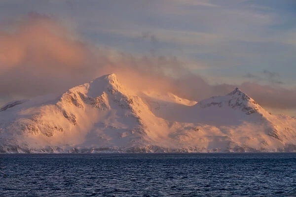 Antarctica, South Georgia Island, Bay of Isles. Sunrise on mountain and ocean