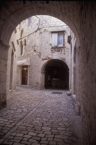 An arched cobbled walkway leads to many residential areas in the central part of Trogir