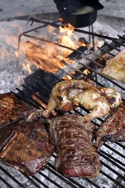 Argentina, El Calafate. Parrillada (mixed grilled meat) cooking on a grill