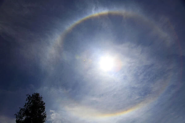 Asia, Bhutan. When a circle appears around the sun, Buddhists in Bhutan believe that