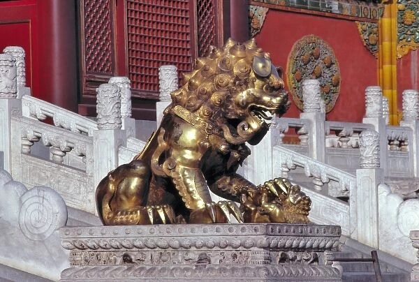 Asia, China, Beijing. A bronze statue of a lion with his paw on a pomegranate guards