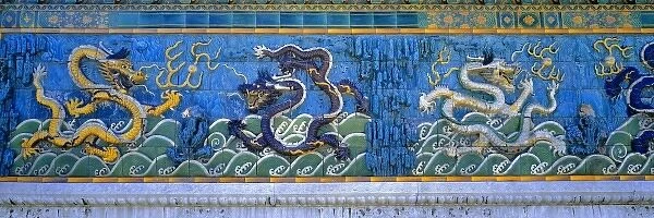 Asia, China, Beijing. Colorful, fanciful dragons regard each other on this tiled