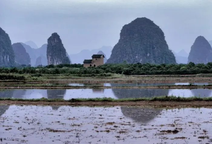 Framed Print : Asia, China, Guilin. A lone house oversees ponds by the karst formations near Guilin