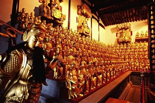 Asia, China, Shanghai. One wall view of golden figures inside Thousand Arhat Hall