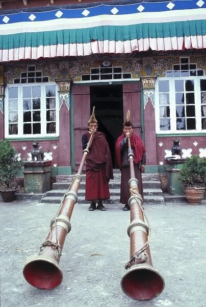 Asia, India, Darjeeling. Buddhist monks at Ghoom Monastery are dwarfed by their enormous