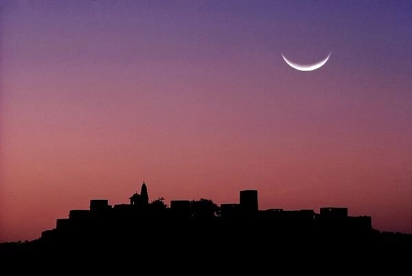 Asia, India, Rajasthan, Jaipur. A crescent moon hangs above the silhouette of Jaipur in Rajasthan
