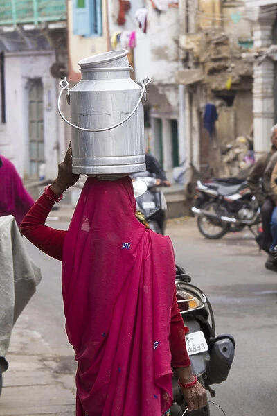 Asia, India, Rajasthan, Udaipur resident with container going to collect fresh goat milk