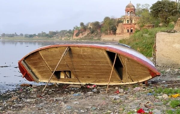 Asia, India, Uttar Pradesh, Agra. A boat alongside the Yamuna River behind the Taj Mahal