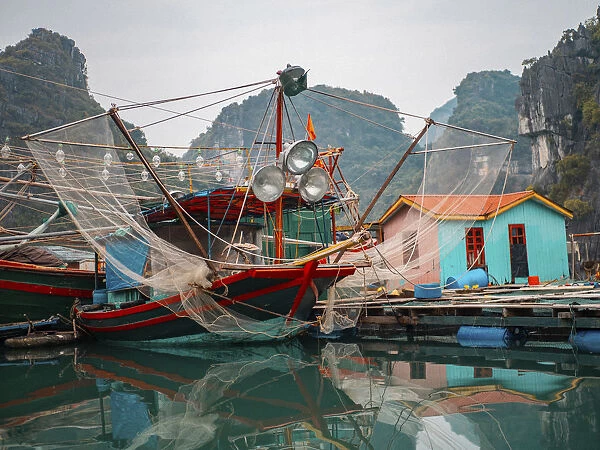 Asia, Vietnam, Quang Ninh, Ha Long Bay. Colorful fishing boat at its dock is reflected