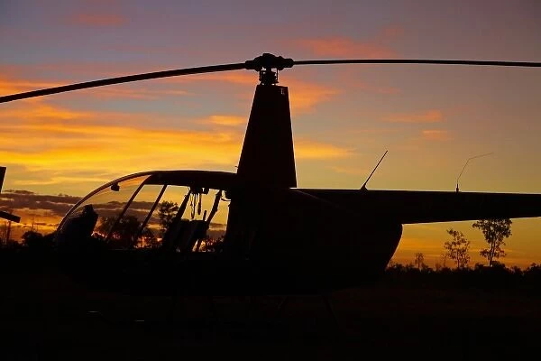 Australia. Robinson R44 helicopter at sunset, Jabiru East Airport