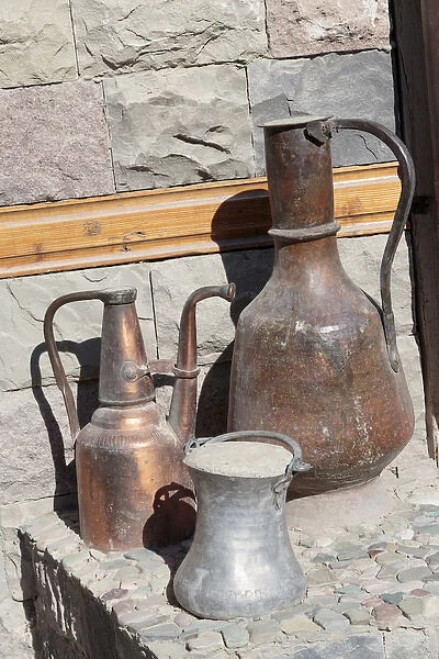 Azerbaijan, Lahic. A copper kettle and jug sitting outside a residence